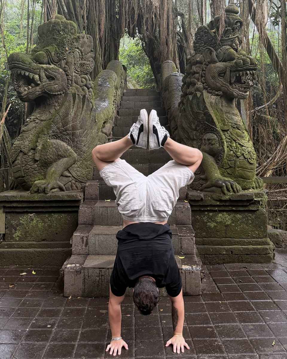 Samuel haciendo el pino frente a un puente con dragones de piedra